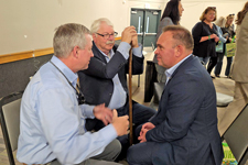 Sandhills Community College President Alexander “Sandy” Stewart speaks with Commissioner of Agriculture Steve Troxler and Dionisie Trnovschi, president of Ungheni province in Moldova.