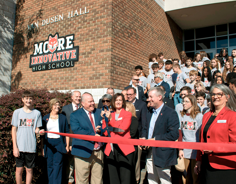 Dr. Tim Locklair, Ashlee Ciccone, Rep. Neal Jackson, Dr. Sandy Stewart, and community leaders join students for the Moore Innovative High School ribbon cutting at Sandhills Community College.