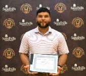 Matthew Goodwin – Student Awards Day Student Matthew Goodwin holding an award certificate and smiling in front of a Sandhills Community College Student Awards Day backdrop.