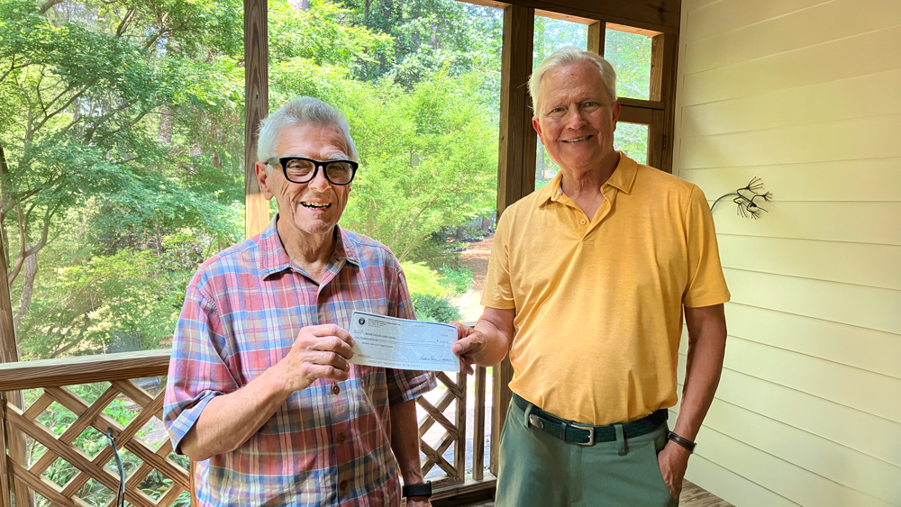 Richard Lane presents a $4,000 grant check to Kyle Sonnenberg.