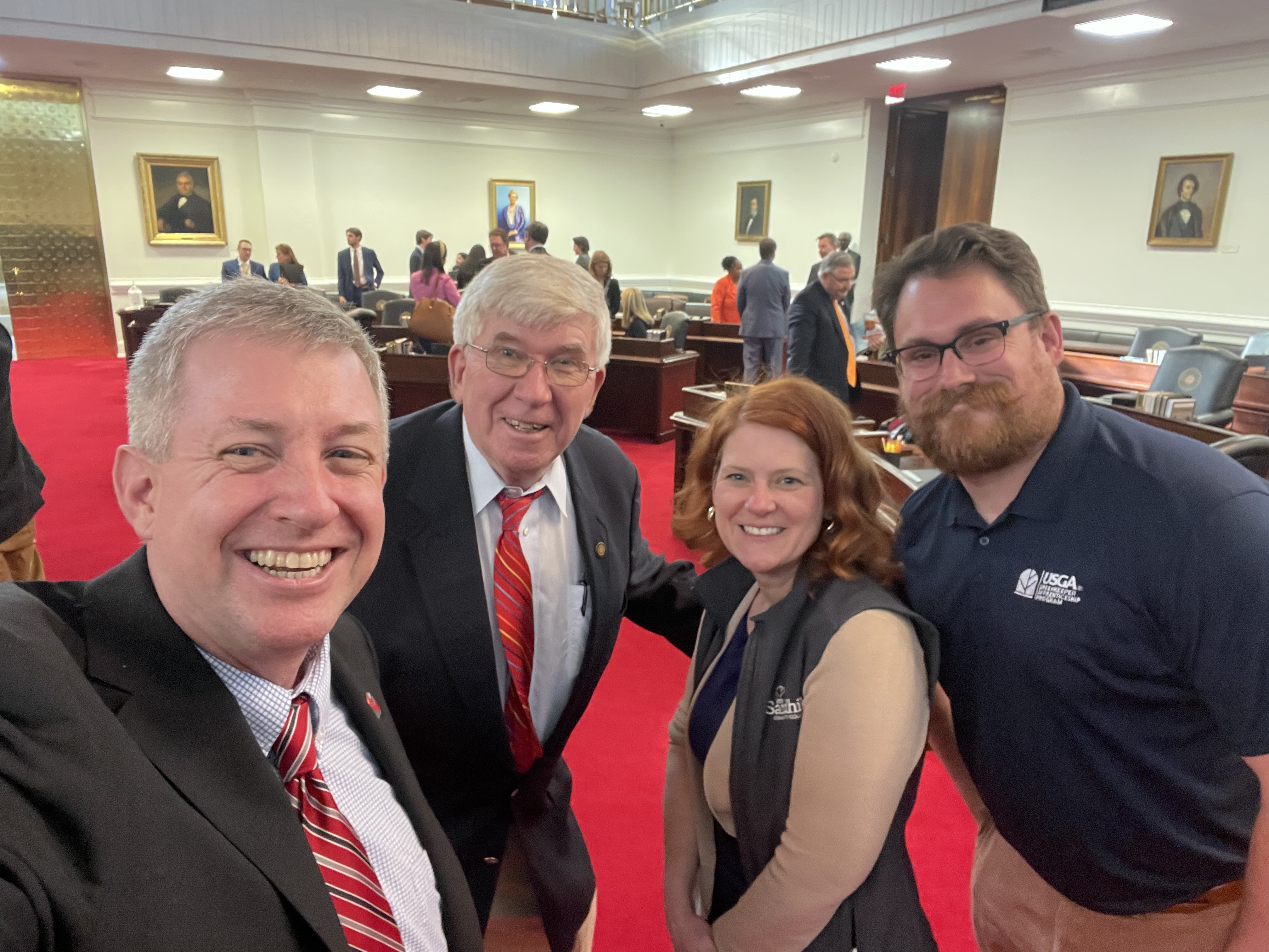 President Alexander “Sandy” Stewart; Chief of Staff and Executive Vice President Julie Voight; USGA Greenskeeper Apprenticeship Program Coordinator Carson Letot (polo shirt); Senator Tom McInnis (Blue jacket) and SCC Trustee Hugh David McLean (Tan jacket) connect during Community College Day in Raleigh this week.