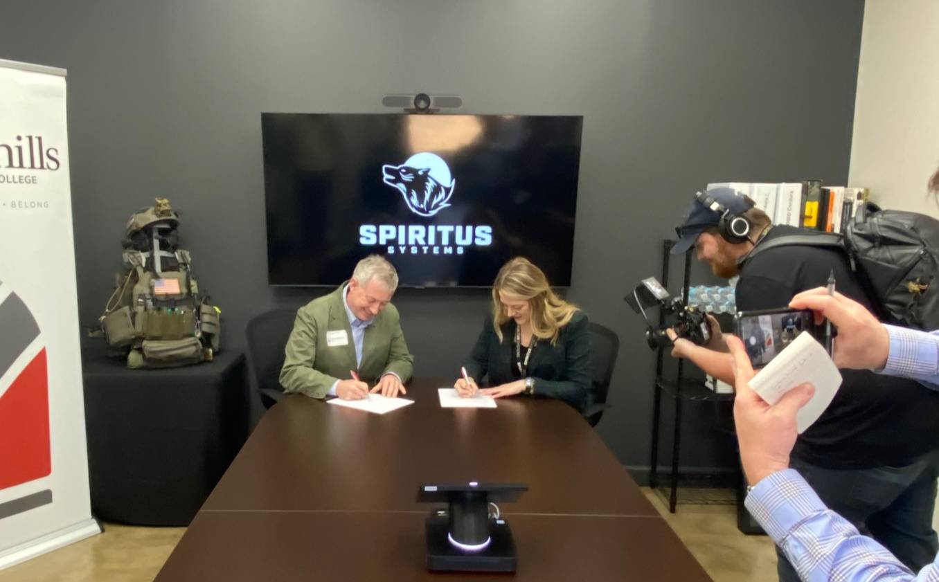 President Sandy Stewart at Sandhills Community College and Nichole Holroyd COO of Spiritus Systems, sign the three-year project plan to offer leadership and professional development opportunities to Spiritus employees by Sandhills Community College faculty, staff and guests.