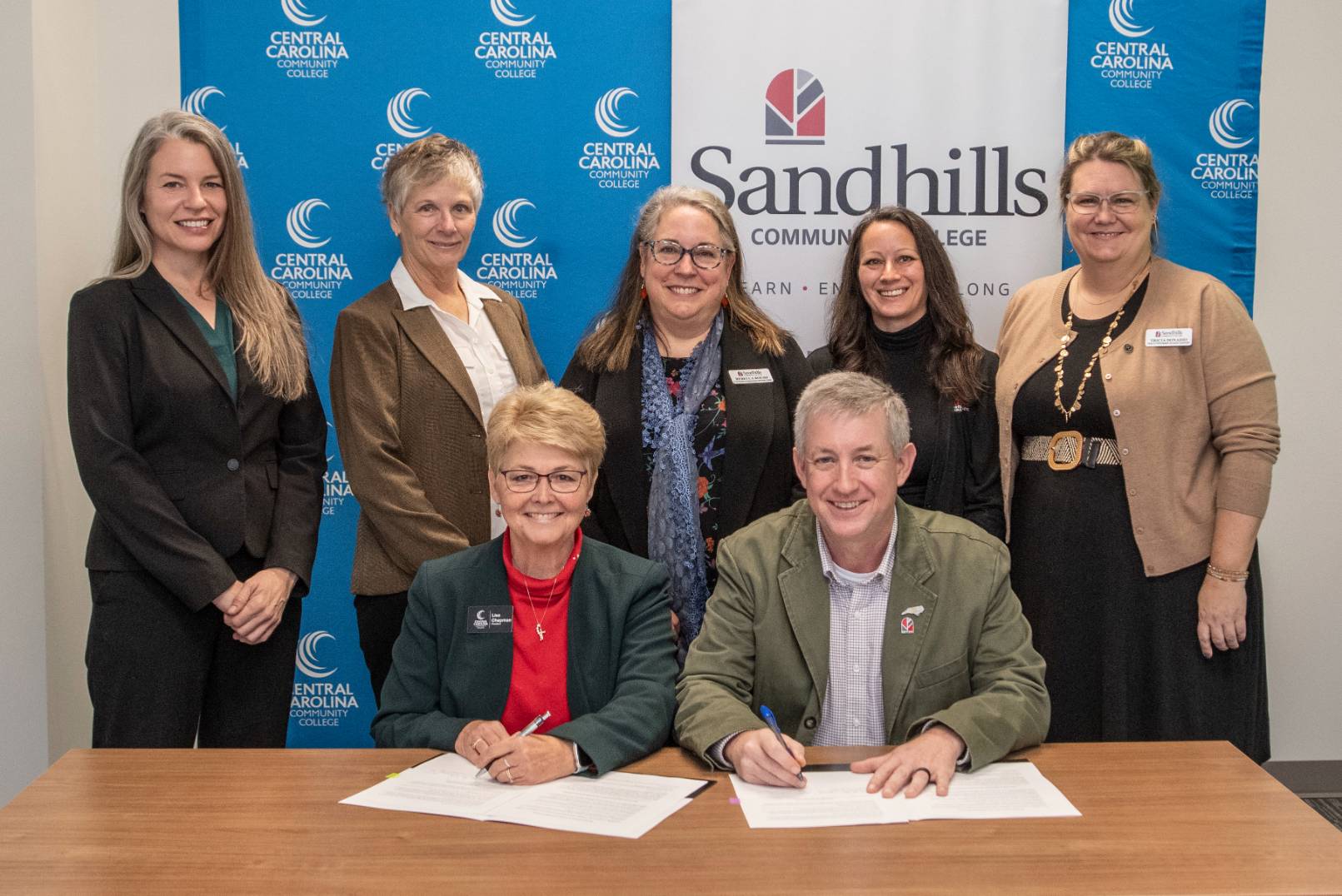 Celebrating the signing: From left to right back row: Dr. Kristi Short, Vice President and Chief Academic Officer from Central Carolina; and from Sandhills Community College, Sue Senior, Senior Professor, Health Sciences; Dr. Rebecca Roush, Senior Vice President of Academic Affairs and Institutional Planning; April Ikner, Director, Student Onboarding and Engagement; and Tricia Donadio, Director of Health Programs Student Support. Front row: President of Central Carolina Community College, Dr. Lisa M. Chapman with Dr. Alexander “Sandy” Stewart, President of Sandhills Community College.